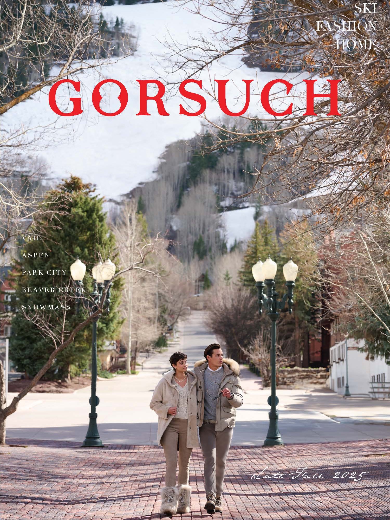 A man and woman walking on cobblestone street in Aspen with mountains in the background, featuring the brand 'Gorsuch'.