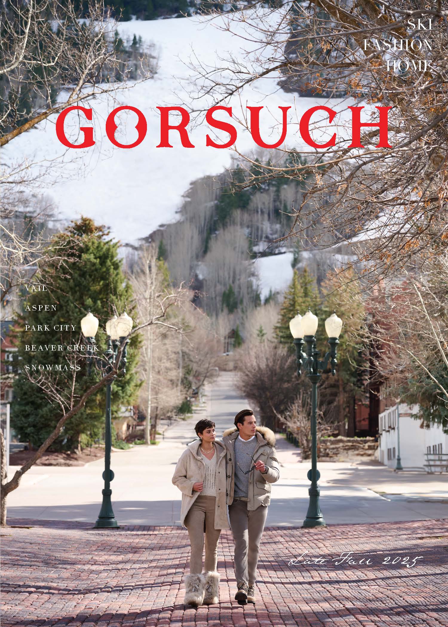 A man and woman walking on cobblestone street in Aspen with mountains in the background, featuring the brand 'Gorsuch'.
