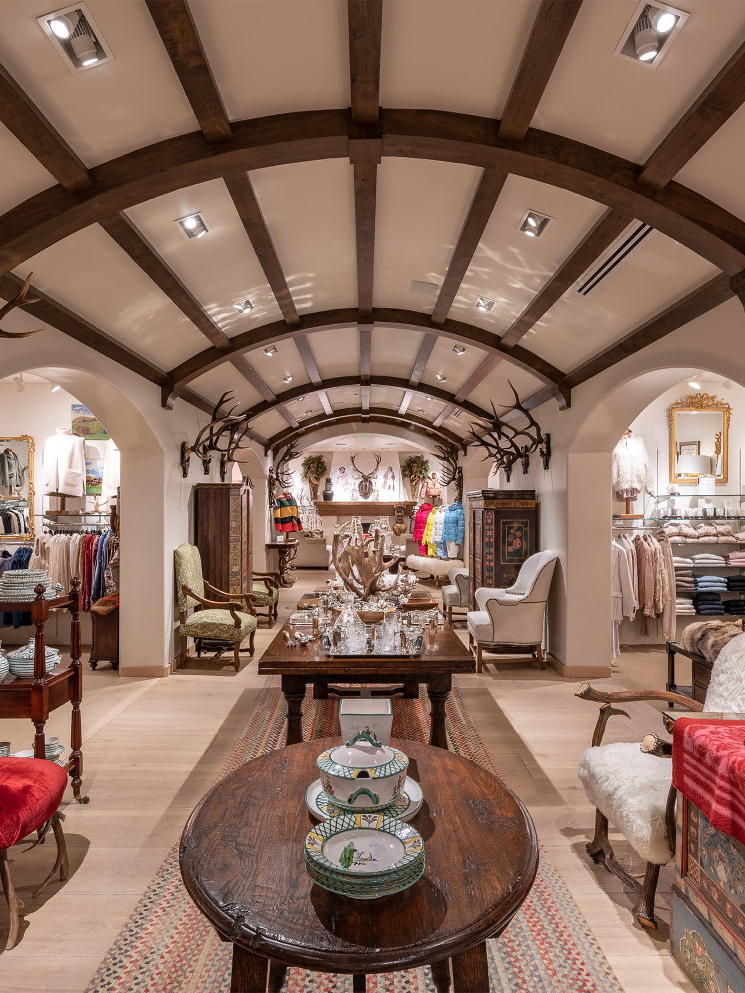 Luxury store interior with wooden tables, chairs, and decorative items at the Gorsuch Store in Park City.