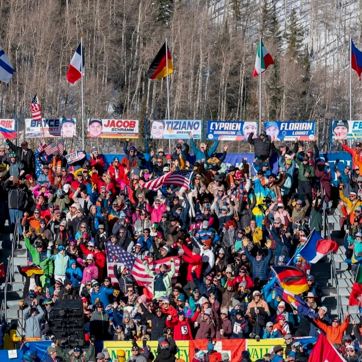 Large crowd of spectators at the World Cup Ski races in Beaver Creek event with flags and banners.