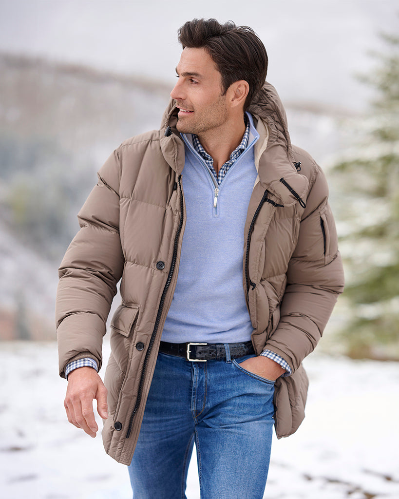 Man wearing a beige puffer jacket in a snowy landscape