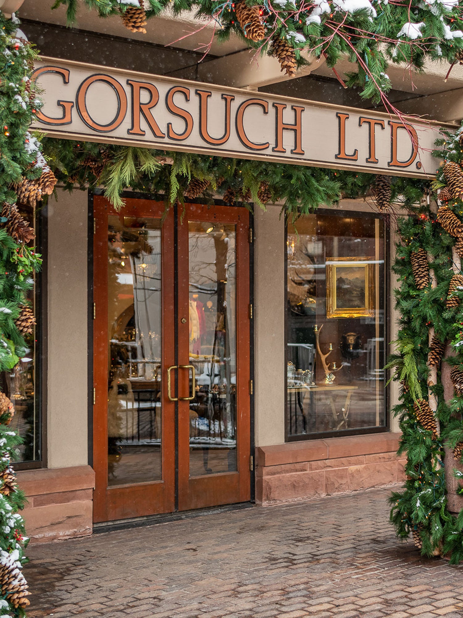 Gorsuch Store in Aspen with Gorsuch LTD sing out front with green garland and picecones decorating the exterior.