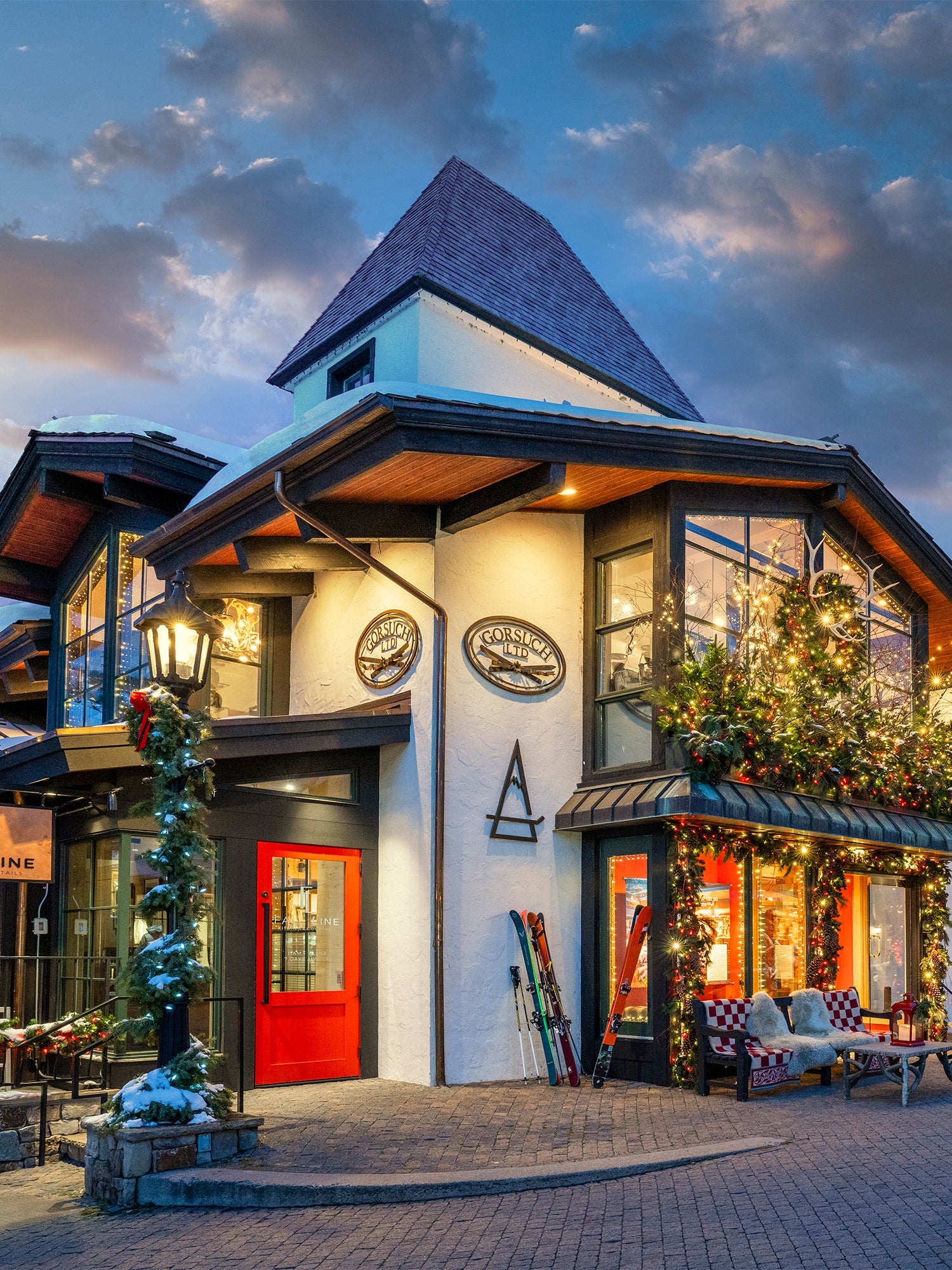 Gorsuch store in Vail Village at dusk, beautifully lit with Christmas decorations and festive holiday lights.