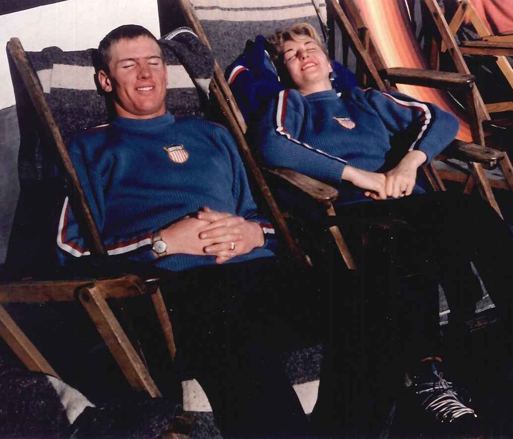 David and Renie Gorsuch wearing matching US Ski Team sweaters lounging in chairs outside in the sun.