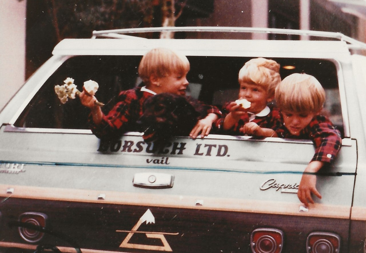 John, Davy and Jeff Gorsuch as children in the back of a vintage station wagon with 'Gorsuch LTD' branding.