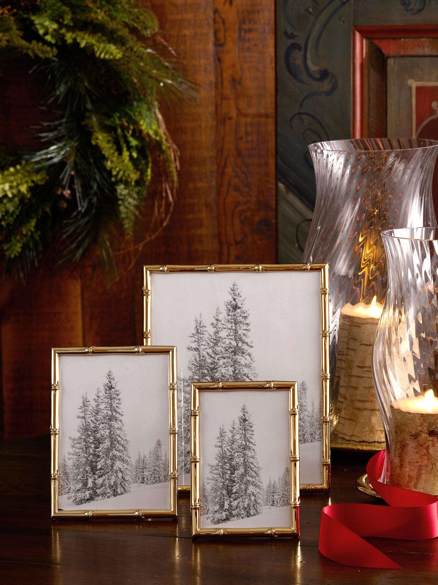 Three gold bamboo frames  on a wooden surface with decorative Christmas elements.