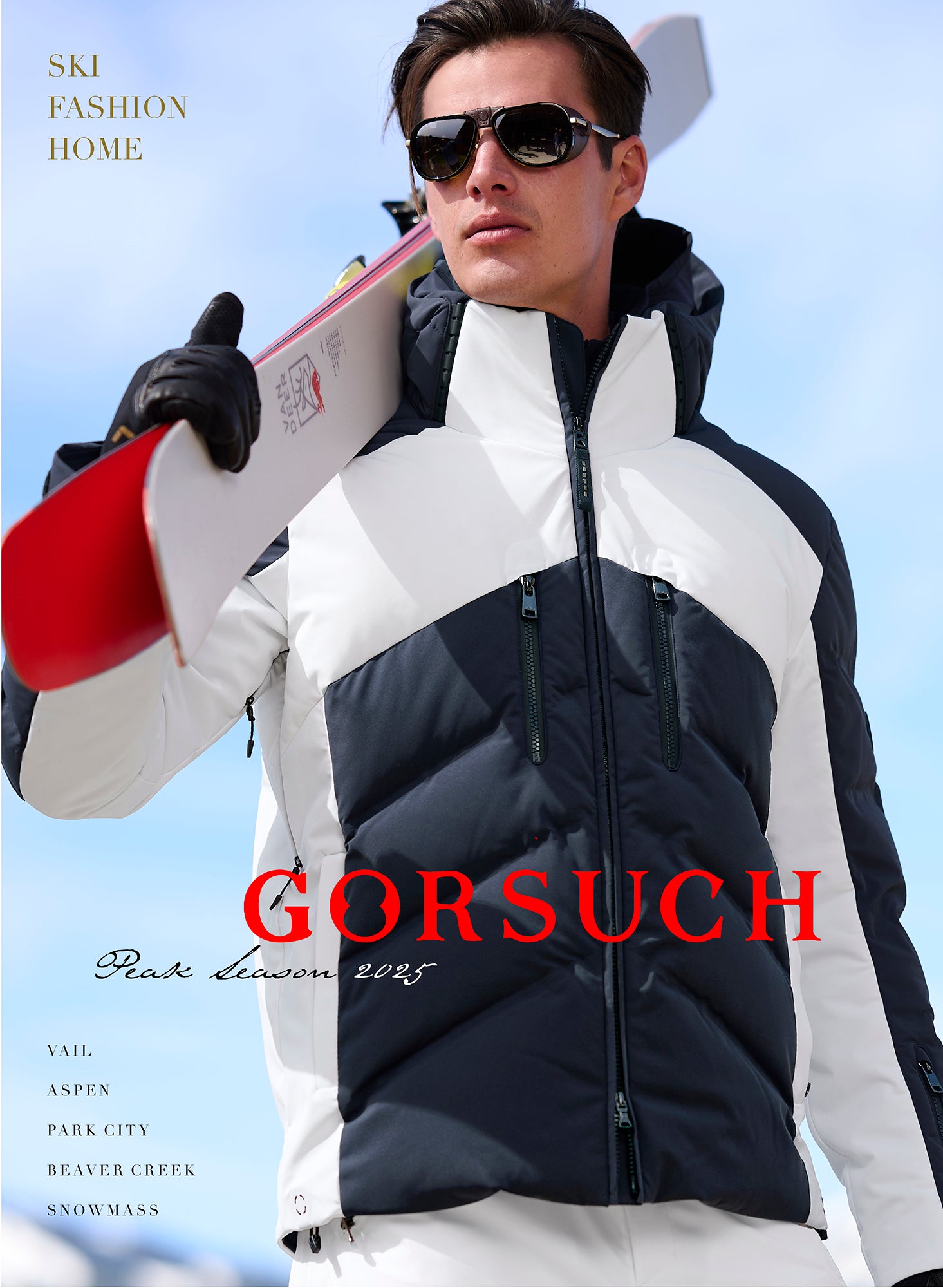 Man wearing navy and white Bogner Jervis Ski Jacket and sunglasses, holding skis against a clear blue sky.