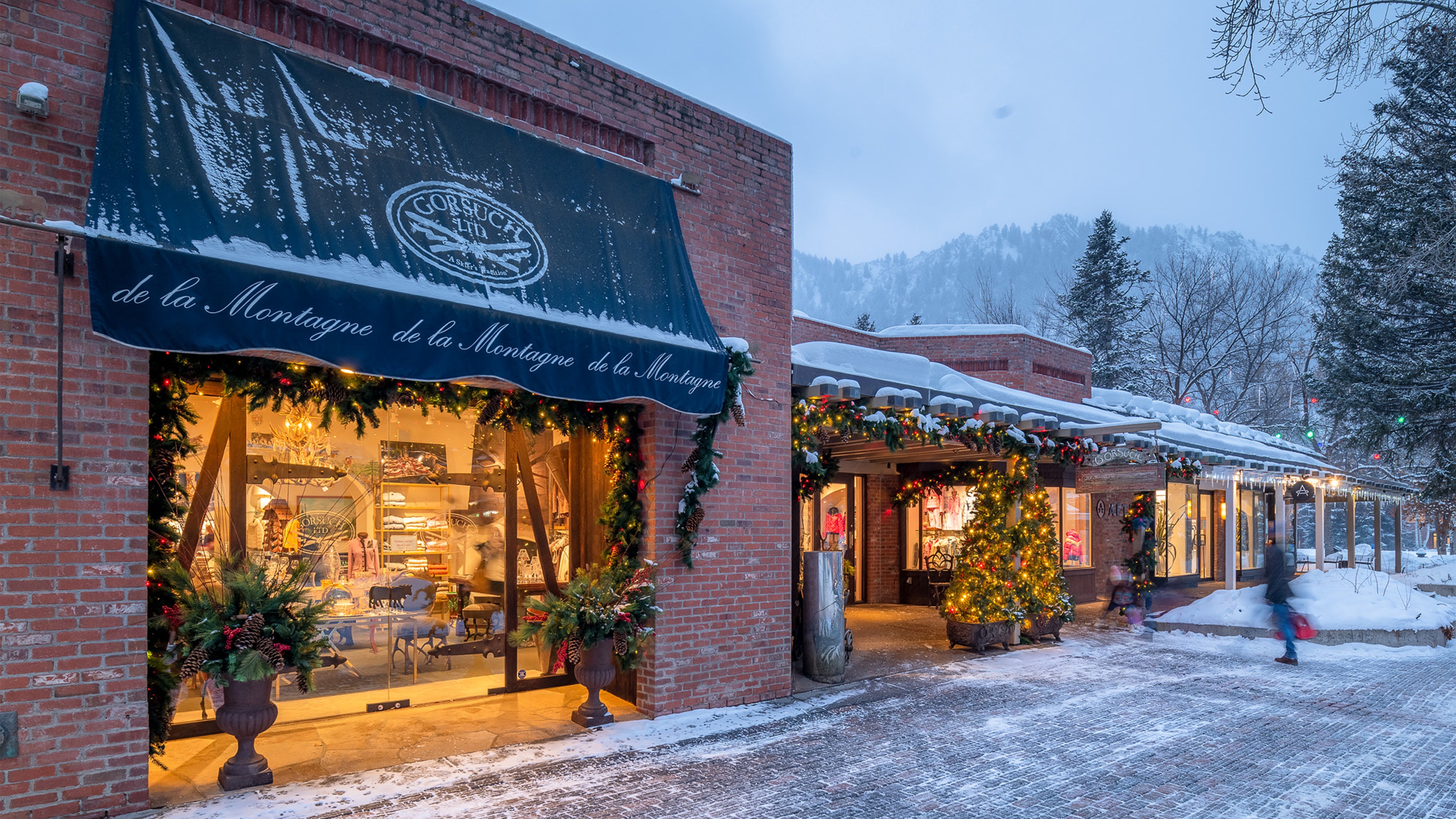 Snowy street scene with the front of the Gorsuch Store on Cooper Street in Aspen  with festive Christmas decorations.