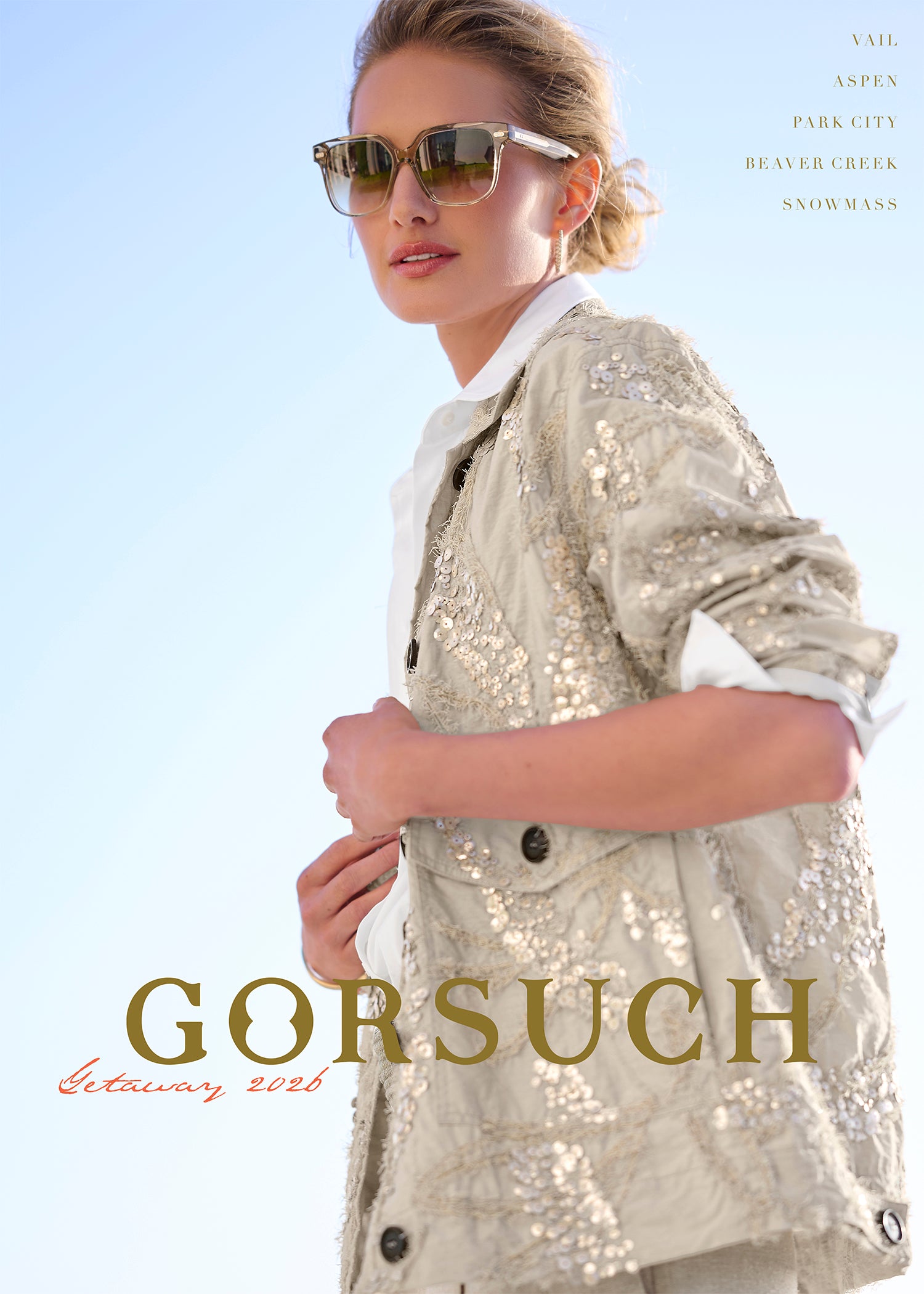 Woman wearing a sequined jacket with sunglasses, standing against a clear blue sky. 'Gorsuch' brand name displayed.