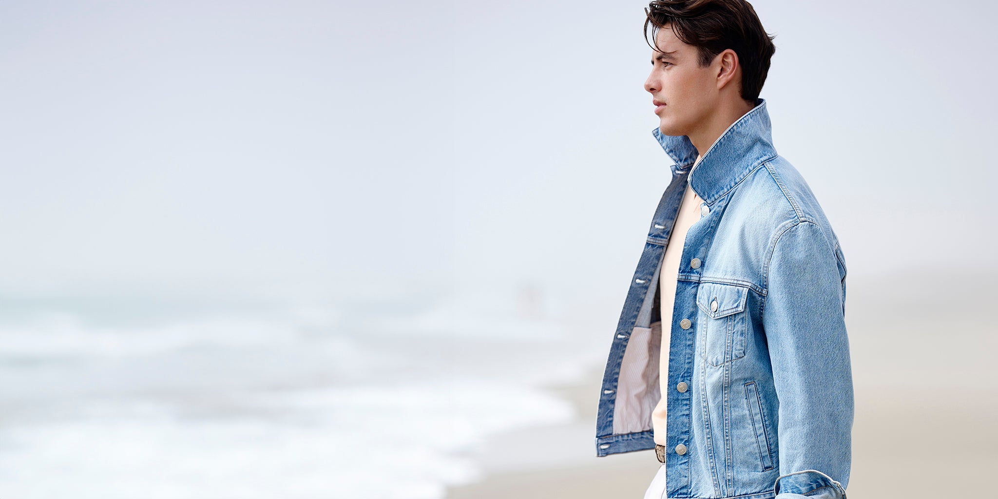 Man wearing a denim jacket against a light gray background