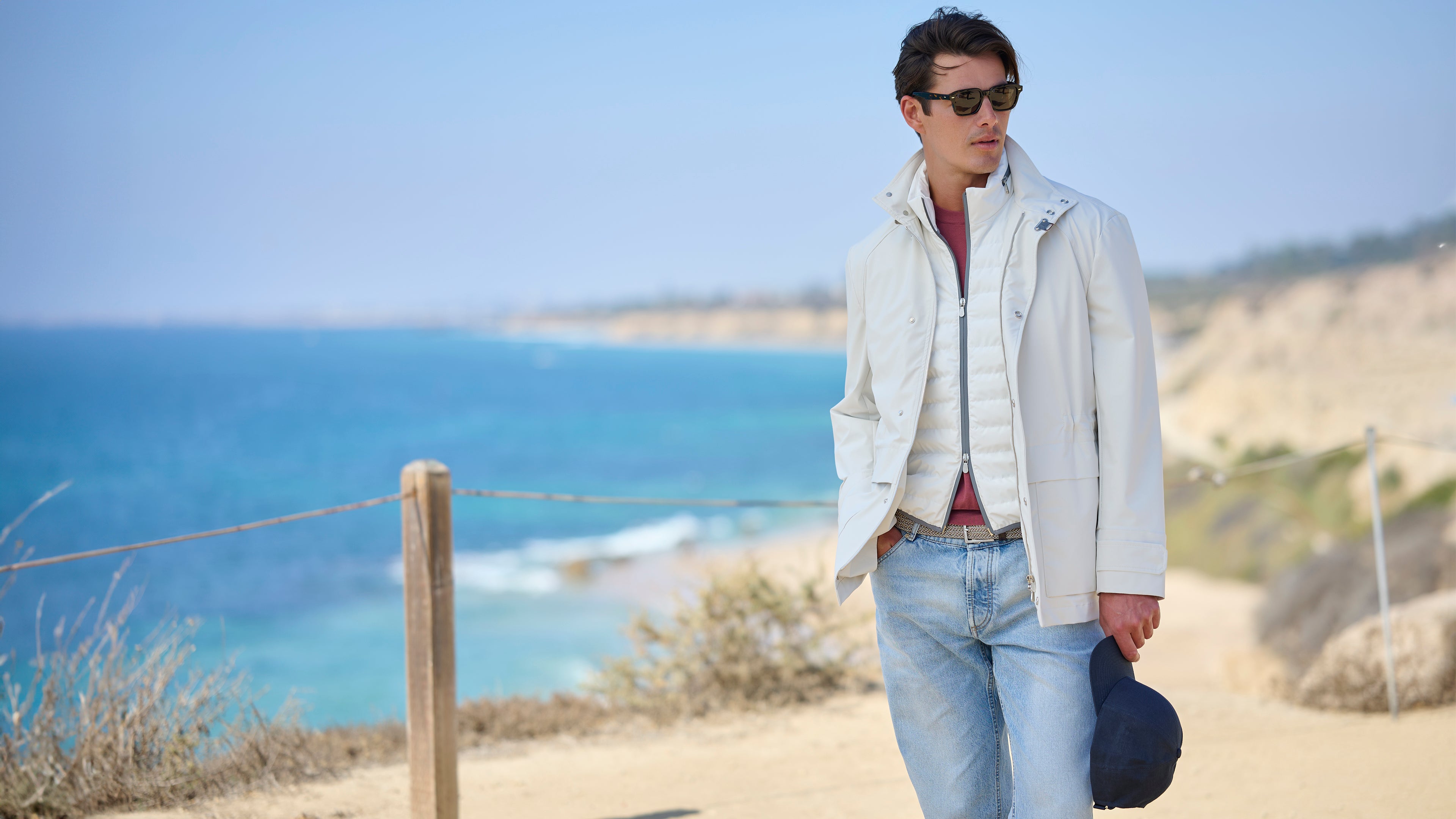 Man walking along a coastal path with ocean view