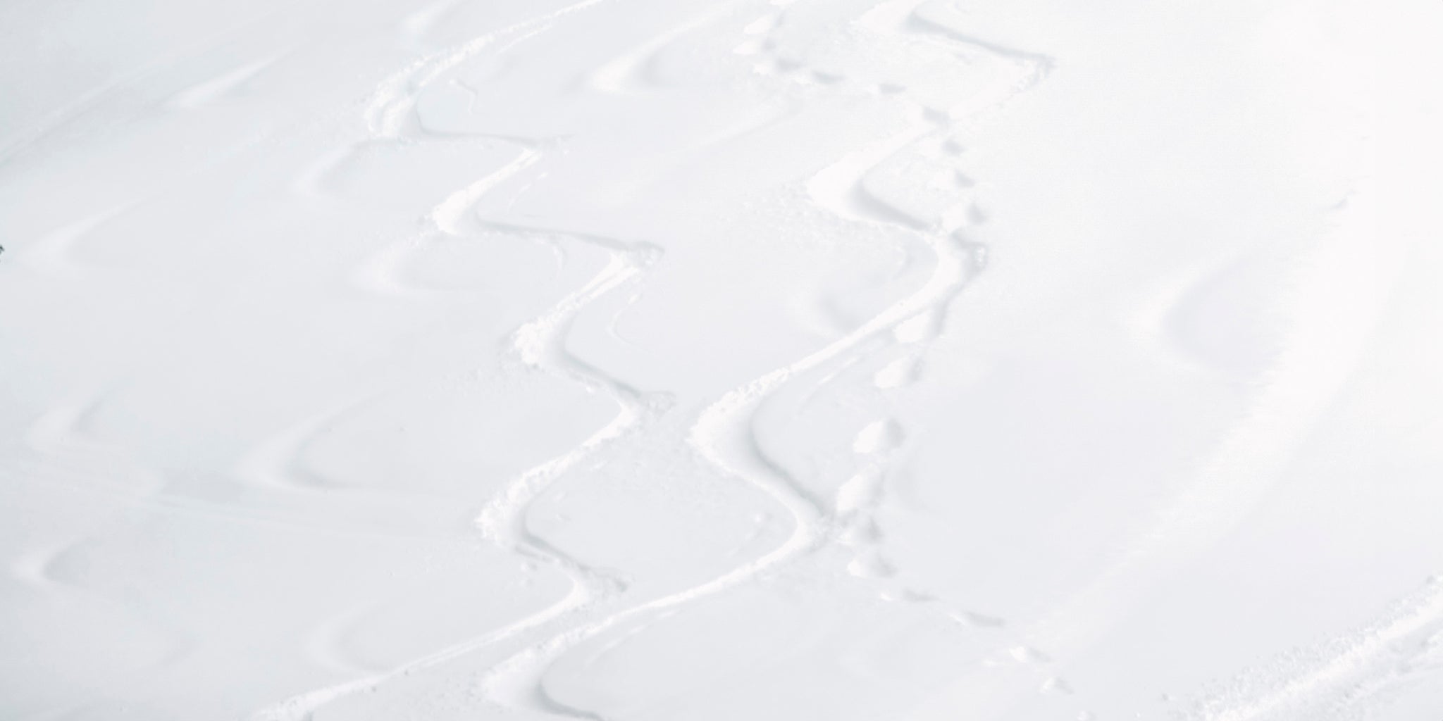 Ski tracks curving down a snow-covered mountain